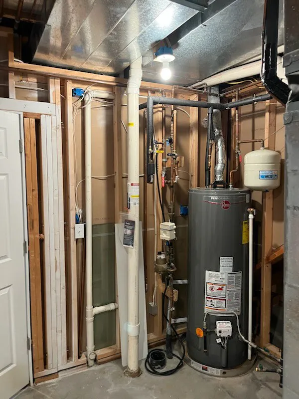 PVC radon mitigation pipe routed through a hot water room in the house