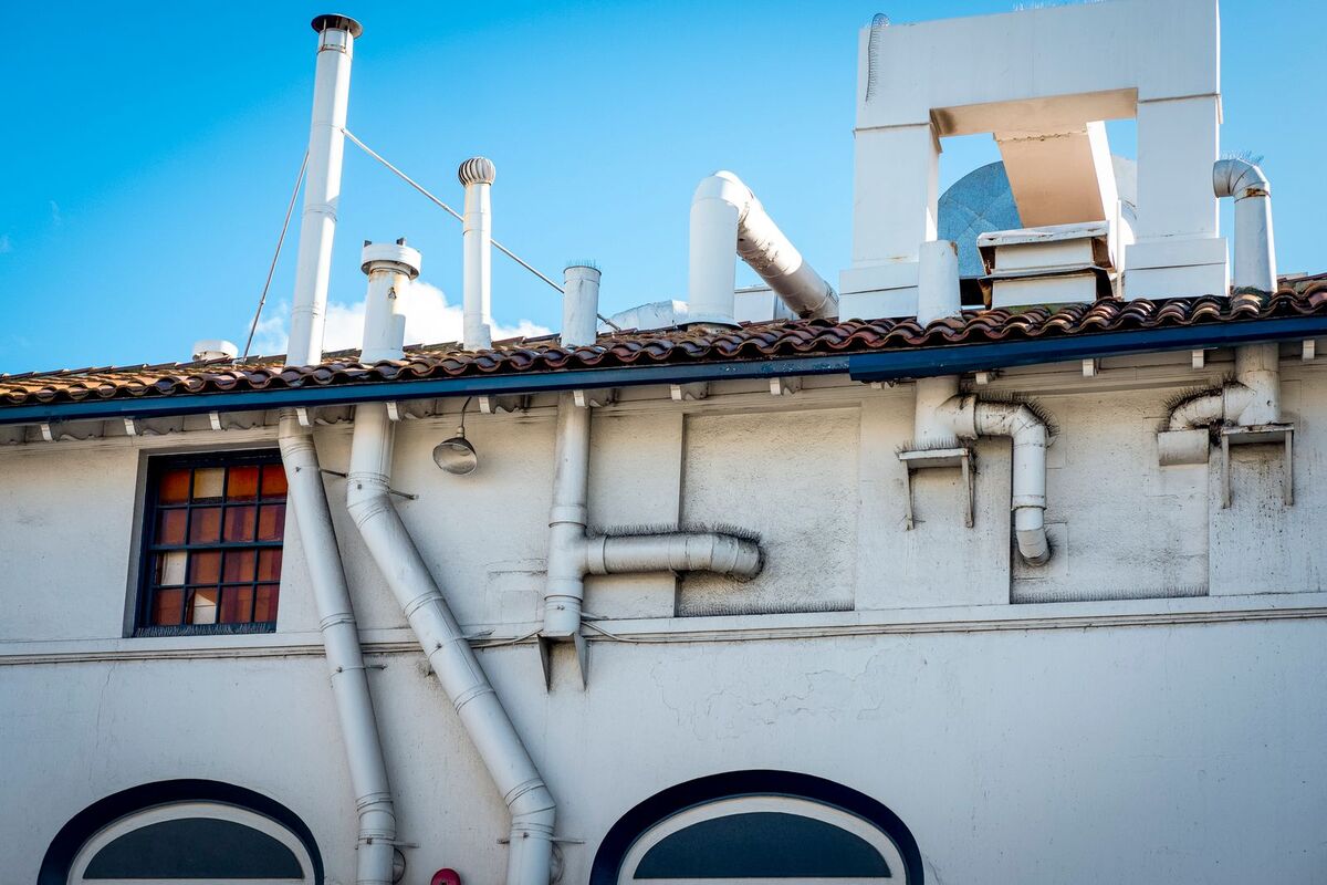 Exterior pipes on building representing vent routing and fan placement